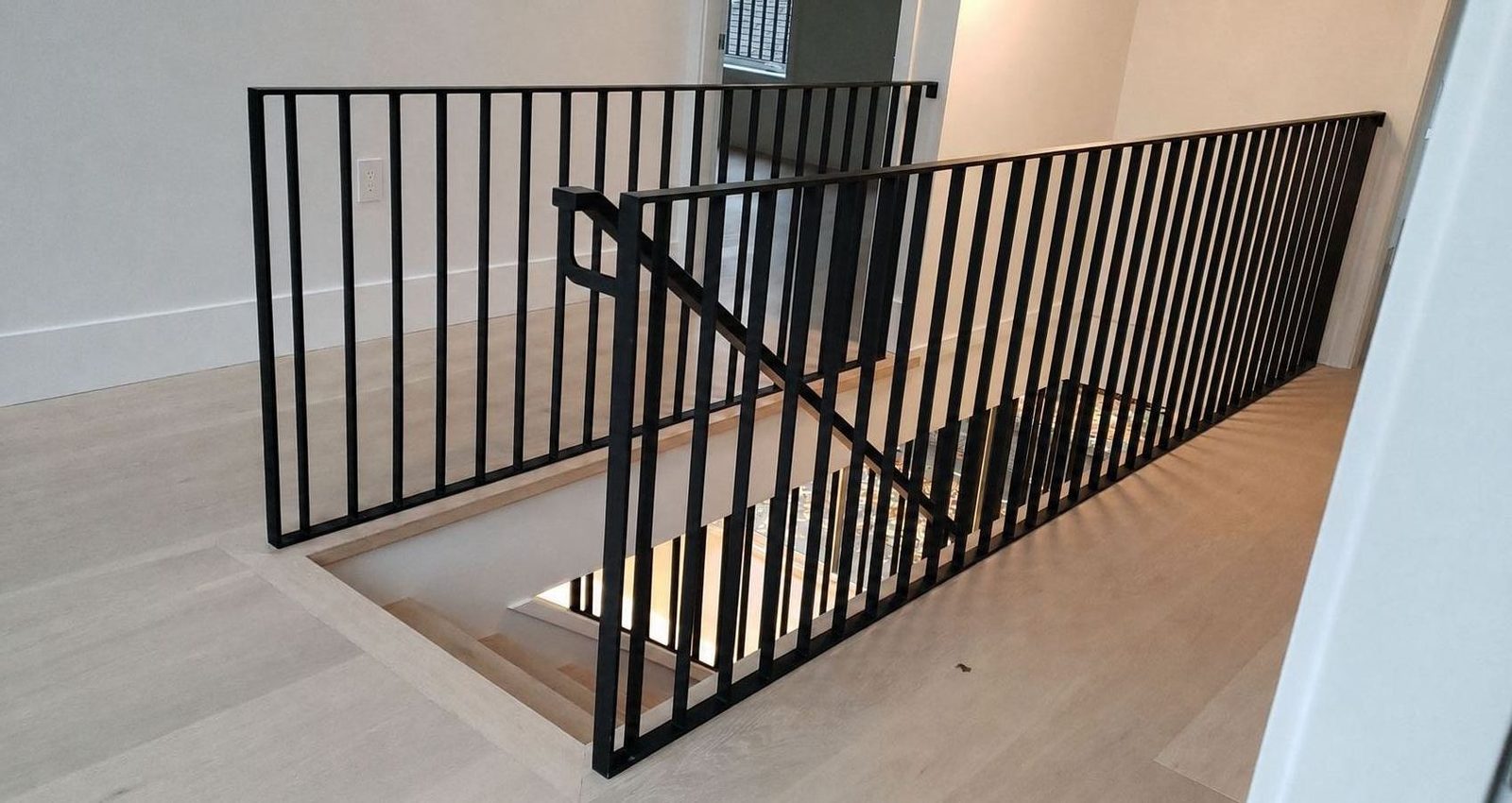 Matte black picket railing along an interior landing and stairwell