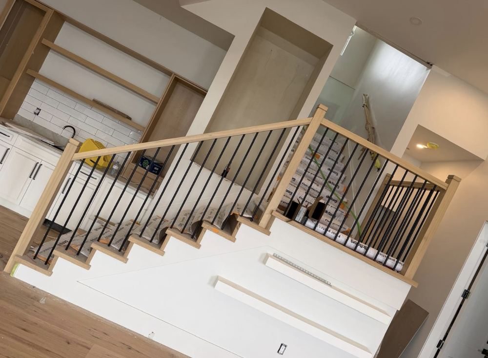 White oak handrail with black metal spindles on a residential staircase