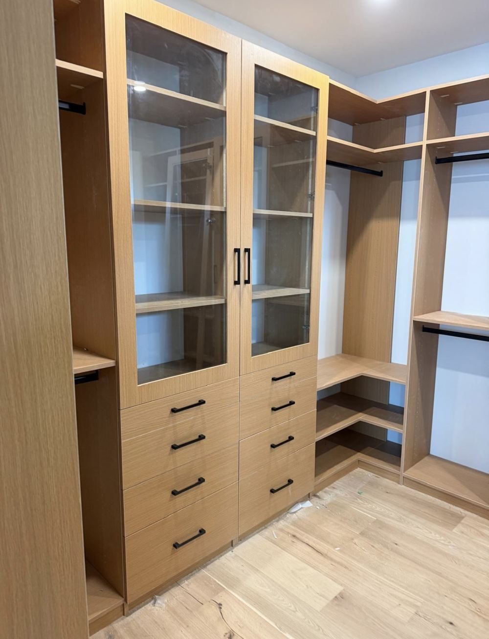 Custom white oak walk-in closet with a glass door display cabinet
